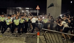 FILE - Police officers use pepper spray during a rally against a proposed extradition law at the Legislative Council in Hong Kong, June 10, 2019.