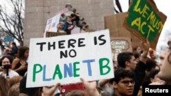FILE - Students hold placards during a demonstration against climate change at Columbus Circle in New York, March 15, 2019. 