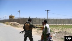 An Afghan National Army (ANA) soldier salutes locals riding on a motorbike outside Bagram Air Base, after all US and NATO troops left, some 70 kilometers north of Kabul on July 2, 2021. 