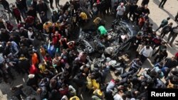 Palestinians inspect a car hit by an Israeli strike in Rafah, Gaza Strip, on Feb. 10, 2024.