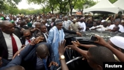 Nigeria's President Muhammadu Buhari (C) is shielded by security after prayers at the Abuja praying ground on the first day of the Muslim holiday of Eid-al-Fitr, marking the end of the holy month of Ramadan in Abuja, Nigeria's capital, July 17, 2015. 