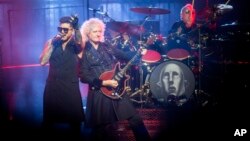 FILE - U.S. singer Adam Lambert performs with British guitarist Brian May (end-R) and drummer Roger Taylor from British rock band Queen during their concert in Papp Laszlo Budapest Sports Arena in Budapest, Hungary, Nov. 4, 2017.