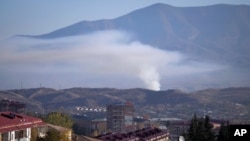 Smoke rises after shelling by Azerbaijan's artillery during a military conflict in Stepanakert, the separatist region of Nagorno-Karabakh, Oct. 24, 2020.