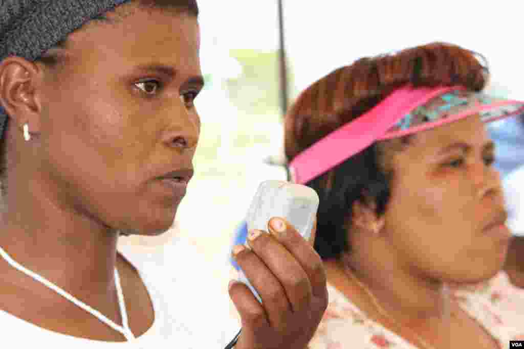 HIV infected sangoma, Veliswa Manundu [left], accompanied by NGO health official Nomzingisi Hopisi, addresses a crowd in Bulungula (VOA / D. Taylor)