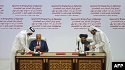 U.S. Special Representative for Afghanistan Reconciliation Zalmay Khalilzad and Taliban deputy chief for political affairs Mullah Abdul Ghani Baradar sign the U.S.-Taliban peace agreement during a ceremony in the Qatari capital Doha, Feb. 29, 2020.