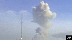 A plume of smoke rises above the skyline from across the river in neighboring Congo Republic's Brazzaville, where around 200 people were killed Sunday when an arms dump exploded, as seen from DRC's capital Kinshasa, March 4, 2012.