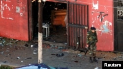 A Lebanese Army soldier guards a cafe where a suicide bomb attack took place in Jabal Mohsen, Tripoli, Jan. 11, 2015.