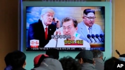 Pemimpin Korut Kim Jong-un (kanan), Presiden Korsel Moon Jae-in (tengah), dan Presiden AS Donald Trump dalam penayangan berita televisi di stasiun kereta Seoul, Kosel, 7 Maret 2018. (Foto: dok). 
