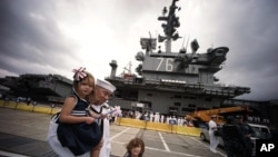 Crew members of U.S. navy nuclear-powered aircraft carrier USS Ronald Reagan reunite their loved ones upon arrival at the U.S. Navy's Yokosuka base in Yokosuka, south of Tokyo Thursday, Oct. 1, 2015.