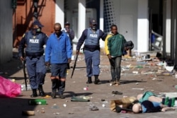 Police officers detain demonstrators during protests following the imprisonment of former South Africa President Jacob Zuma, in Katlehong, South Africa, July 12, 2021.