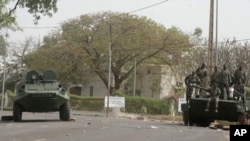 Soldiers secure the area along a road outside the presidential palace after a military coup in Bamako, Mali, Friday March 23, 2012.