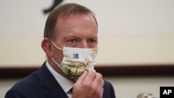 FILE - Former Australian Prime Minister Tony Abbott wears a mask with the Chinese character for "Australia" during a meeting with Taiwanese President Tsai Ing-wen, Oct. 7, 2021, at the Presidential Office in Taipei, Taiwan.