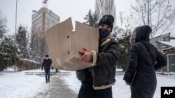 An election worker brings food to a polling station in parliamentary elections in the capital, Pristina, Kosovo, on Feb. 14, 2021.
