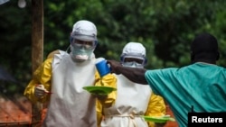 FILE - Medical staff working with Medecins Sans Frontieres (Doctors Without Borders) deliver food to the isolation area of an Ebola treatment center in Sierra Leone's Kailahun district, July 20, 2014.