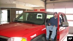 Steve Kitchin demonstrates his prototype invention. With the touch of a button he simply backs the chair in, and the elevator-like lift raises up and slides into the cab.
