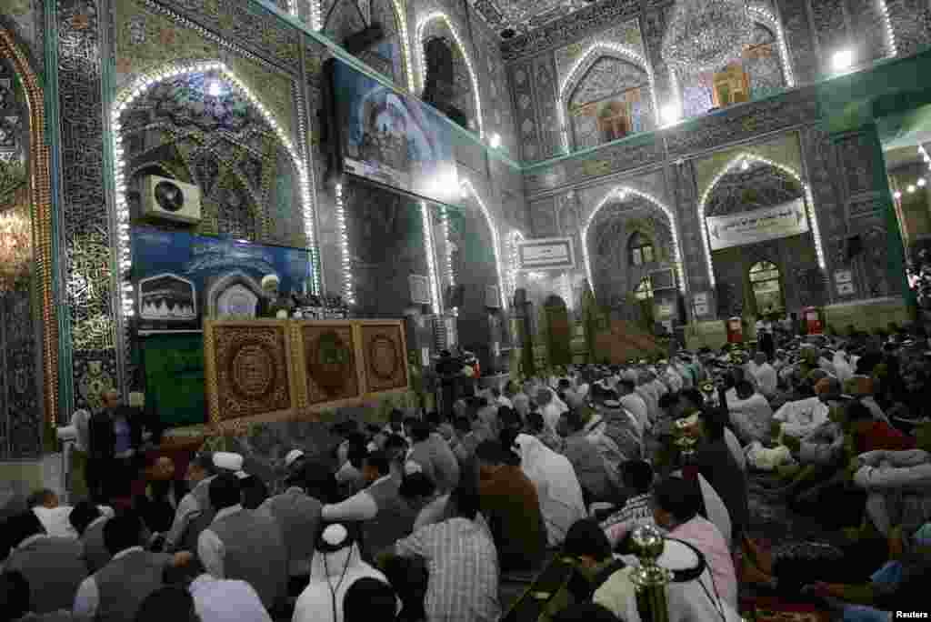 Shi'ite Muslims listen to Sheikh Abdul Mehdi Al-Karbala'i speak as he delivers the text of a sermon by Iraq's top Shi'ite cleric Grand Ayatollah Ali al-Sistani, during Friday prayers at the Imam Hussein shrine in the holy city of Karbala, Aug. 8, 2014.