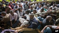 A Kenyan student is prodded in the head by a riot policeman's club inside Nairobi University's main campus, Nairobi, May 20,2014
