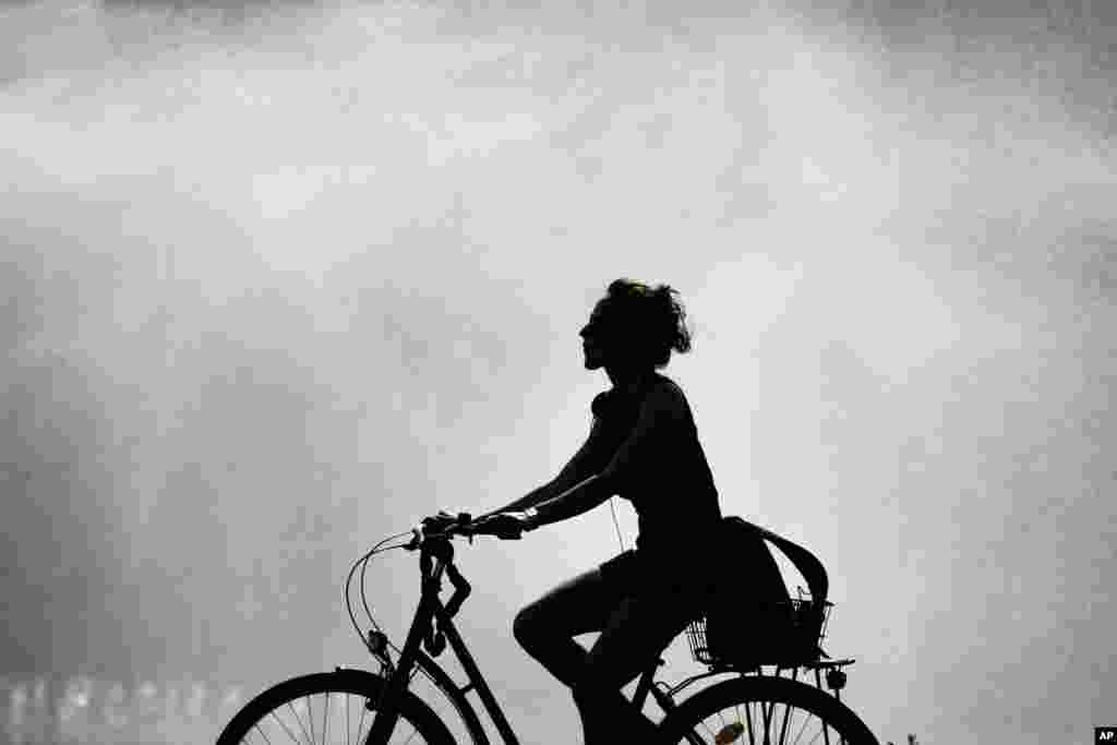 ស្រ្តី​ម្នាក់កំពុង​ជិះកង់​នៅ​ក្នុង​ពេល​ព្រះ​អាទិត្យ​កំពុង​ចែងចាំង​នៅ​ទីក្រុង​ប៊ែរឡាំង​ប្រទេស​អាល្លឺម៉ង់។ &nbsp;