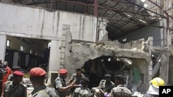 People gather at the bombed office of ThisDay, an influential daily newspaper, Abuja, Nigeria, April 26, 2012.