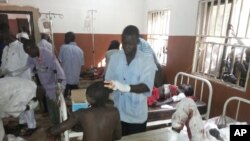 Petugas merawat korban luka-luka akibat ledakan bom bunuh diri di Potiskum, Nigeria (10/11).