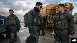 Израелски војници запалија свеќа на седмата ноќ на Ханука пред да бидат распоредени во појасот Газа во близина на границата меѓу Израел и Газа во јужен Израел, 31 декември 2024 година