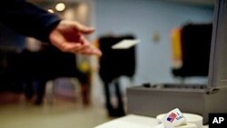 A voter returns his polling card after casting his ballot at a polling station in Queen Anne, Maryland, 02 Nov 2010