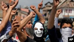 Masked Kashmiri protesters hold bricks as they shout freedom slogans in Srinagar, India, May. 27, 2017. One civilian was killed and dozens of others injured Saturday after massive anti-India protests and clashes erupted in Indian-controlled Kashmir following the killing of a prominent rebel commander and his associate.
