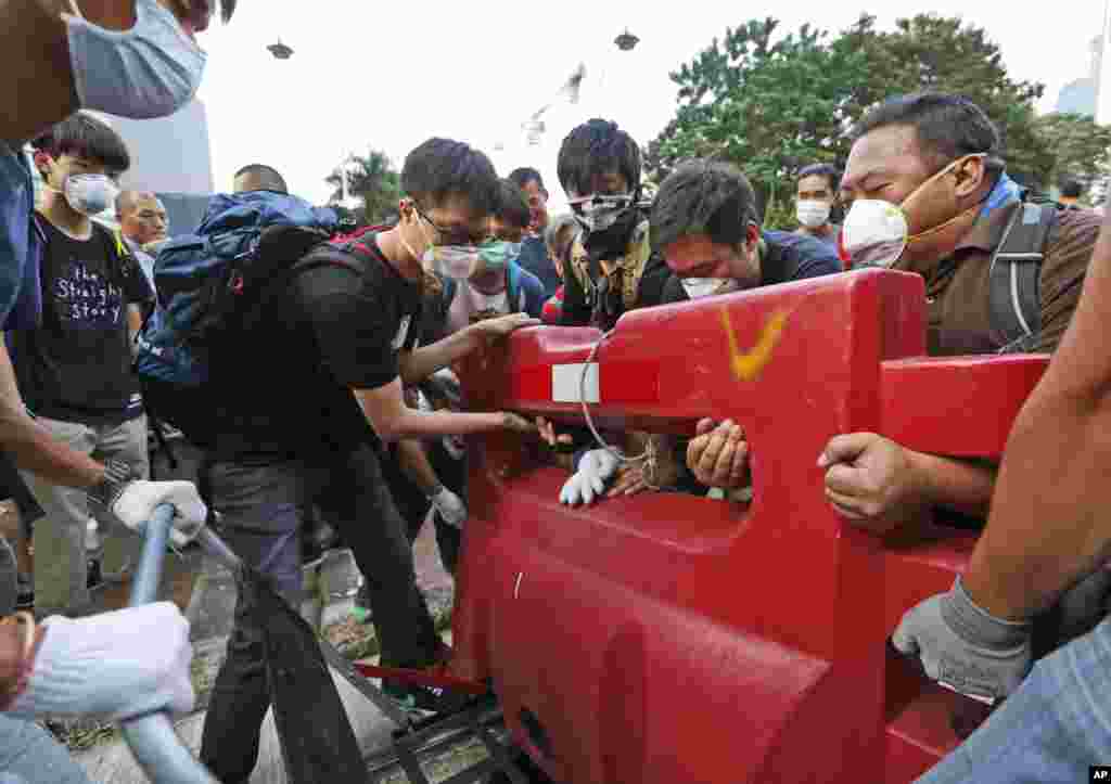 Pro-democracy demonstrators build a barricade on the main road in the occupied areas outside the government headquarters in Hong Kong's Admiralty district, Oct. 13, 2014. 