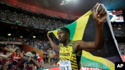 Jamaica's Usain Bolt celebrates after winning the gold medal in the men's 100m ahead of United States' at the World Athletics Championships at the Bird's Nest stadium in Beijing, Sunday, Aug. 23, 2015. 