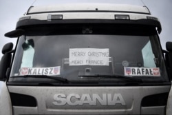 A sign in the window of a truck driver's cab reads "Merry Christmas, Merci France", as the heavy goods vehicle sits in a queue trying to enter the Port of Dover, in Kent, south east England, Dec. 23, 2020.