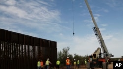 Workers break ground on new border wall construction about 20 miles west of Santa Teresa, N.M., Aug. 23, 2019. The wall visible on the left was built in 2018. The new construction is funded by money reallocated from the Department of Defense. 