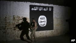 FILE - An Iraqi soldier inspects a former train tunnel displaying the the Islamic State group flag, in western Mosul, Iraq, March 1, 2017. The tunnel once served as a training camp for IS fighters.