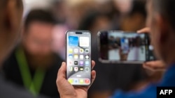 A person looks at an Apple iPhone 15 Pro during a launch event at Apple Park in Cupertino, California, on September 12, 2023. (Photo by Nic Coury / AFP)