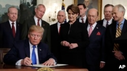 US President Donald Trump signs a presidential memorandum imposing tariffs and investment restrictions on China in the Diplomatic Reception Room of the White House, March 22, 2018, in Washington. 