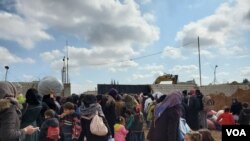 The gate to Manbij, Syria, where displaced families wait to enter, seeking relative safety hundreds of kilometers from Idlib. Feb. 21, 2020. (Heather Murdock/VOA)