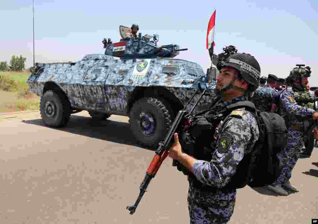 Iraqi federal police officers patrol in Baghdad's Abu Ghraib suburb, June 28, 2014.