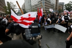 FILE - U.S. Secret Service uniformed officers tear apart barricades as they clash with anarchists and antifa counterprotesters trying to block white nationalists from departing their rally across from the White House, marking the one-year anniversary of the 2017 Charlottesville, Virginia, protests, Aug. 12, 2018.