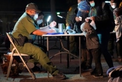 A child rests its head on a table as a U.S. Customs and Border Protection officer processes migrants who crossed into the U.S., March 24, 2021, in Roma, Texas.