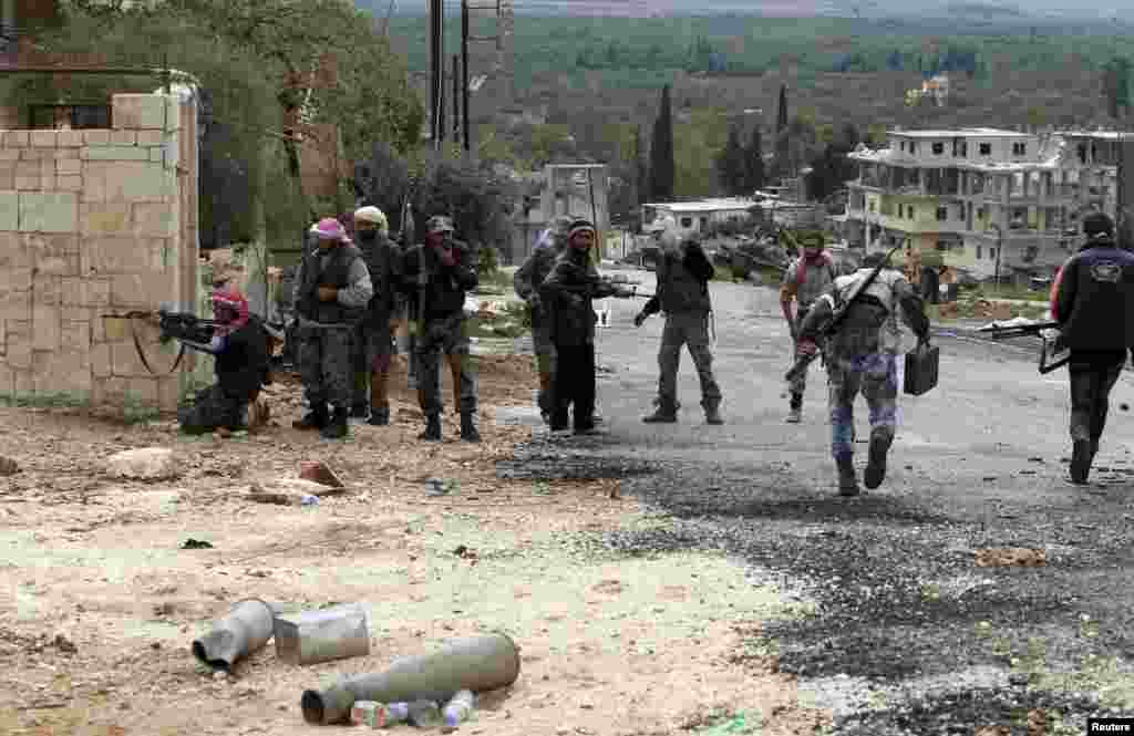 Members of the Free Syrian Army watch for snipers during fighting against pro-government forces in Harem, Idlib, Syria, October 25, 2012. 