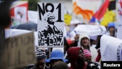 Demonstrators carry placards as they march to protest against corruption in Cape Town, South Africa, Sept. 30, 2015. 