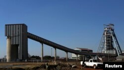 FILE - A man walks past the Doornkop Gold Mine, about 19 miles west of Johannesburg. Mining output fell by 4.5 percent year-on-year in January, according to Statistics South Africa.