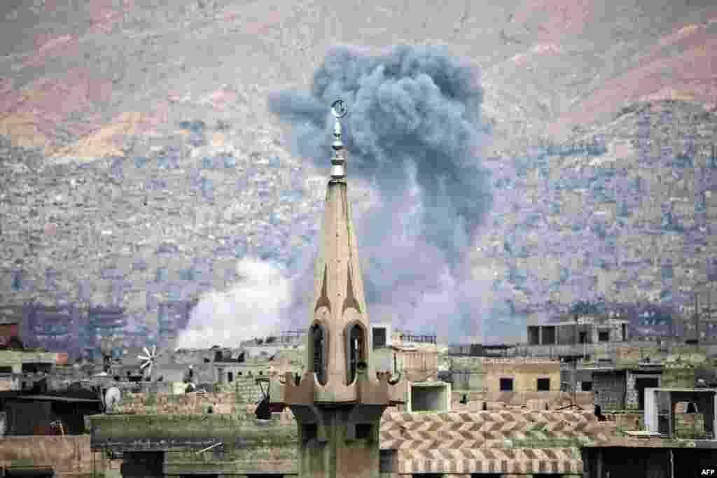 Asap mengepul akibat serangan udara pasukan Suriah terhadap posisi pemberontak di distrik Jobar, di pinggiran ibukota Damaskus.