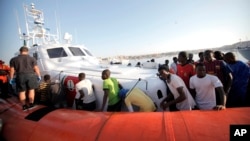 Migrants prepare to disembark in the island of Lampedusa, Italy, Aug. 7, 2013, after being rescued at sea by the Italian Coast Guard. 
