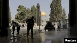 Palestinians clean the Al-Aqsa mosque after clashes between Israeli police and Palestinians on the compound known to Muslims as Noble Sanctuary and to Jews as Temple Mount in Jerusalem's Old City, Sept. 15, 2015. 
