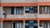 People spend time on their balconies talking to each other at a government-designated quarantine facility in Nairobi, April 6, 2020.