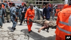 An Afghan municipality worker carries the body of a Taliban after clashes in front of the Parliament, in Kabul, Afghanistan, June 22, 2015. 
