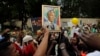 As pessoas cantam à porta da casa de Nelson Mandela em Joanesburgo, Dez. 9, 2013.
