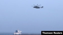 FILE - A U.S CH-53E Super Stallion aircraft flies over a tanker in the Arabian Sea off Oman, July 17, 2019.