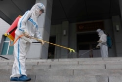 Staff of the Pyongyang Primary School No. 4 spray disinfectant in Pyongyang, North Korea, June 30, 2021.