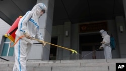 Staff of the Pyongyang Primary School No. 4 spray disinfectant in Pyongyang, North Korea, June 30, 2021, as Kim Jong berated top officials for failures in coronavirus prevention that caused a ‘great crisis.’